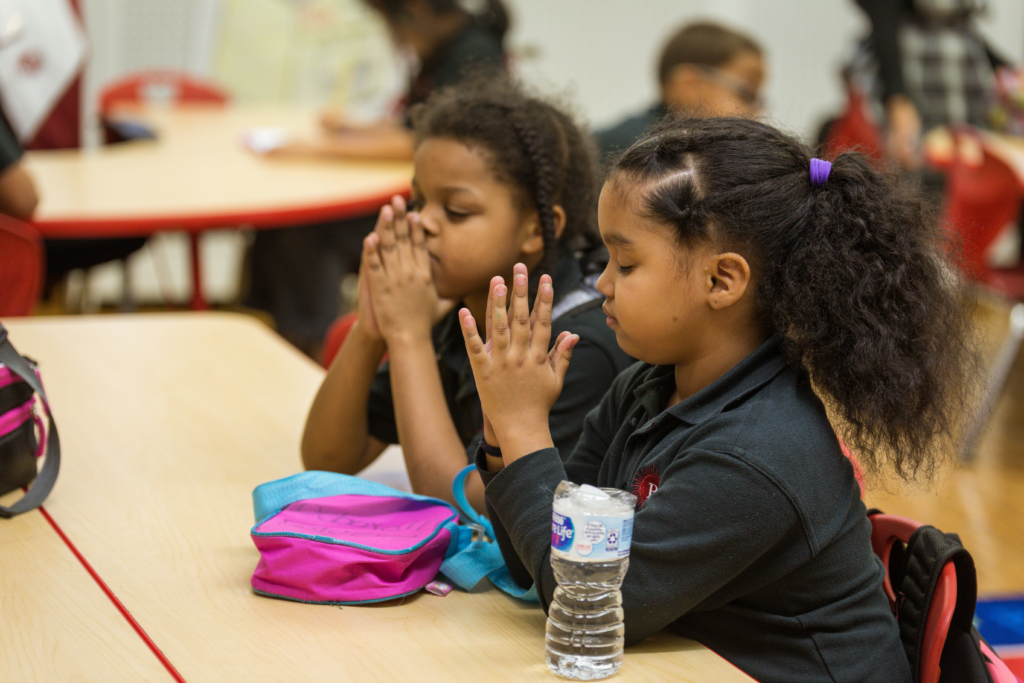 Young students from a catechism class engaging in prayer and meditation.