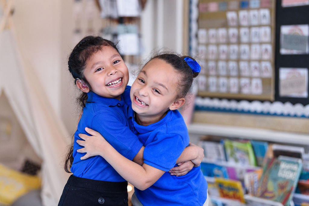 Scholars joyfully embracing at one of our schools